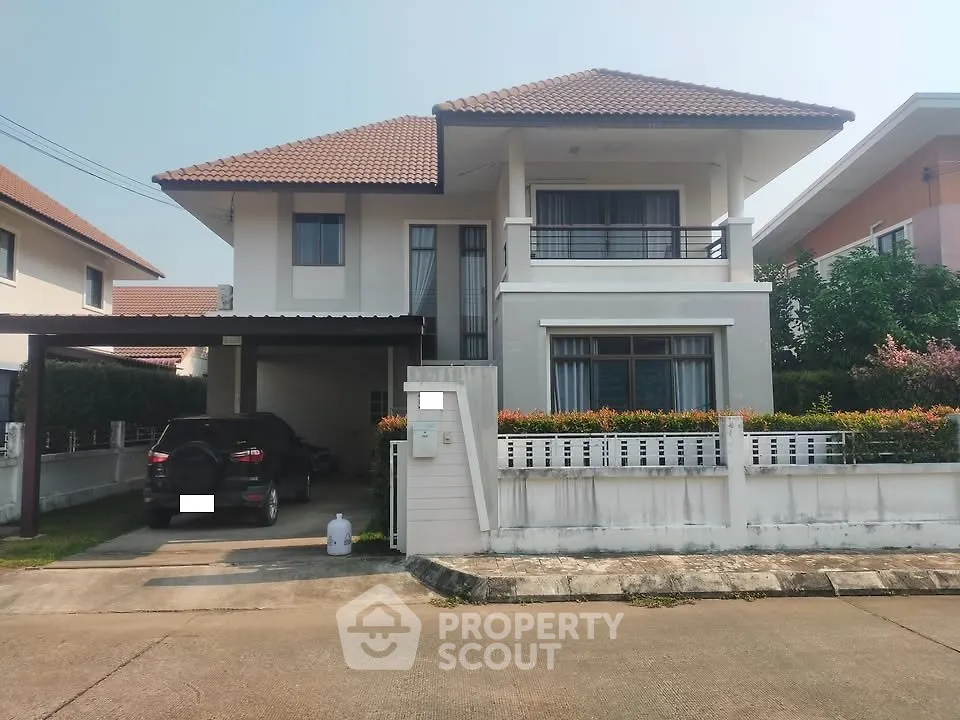 Charming two-story house with a carport and modern design in a serene neighborhood.