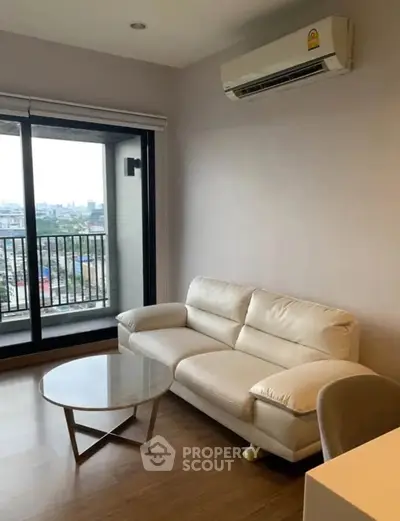 Modern living room with white sofa and city view balcony in high-rise apartment.