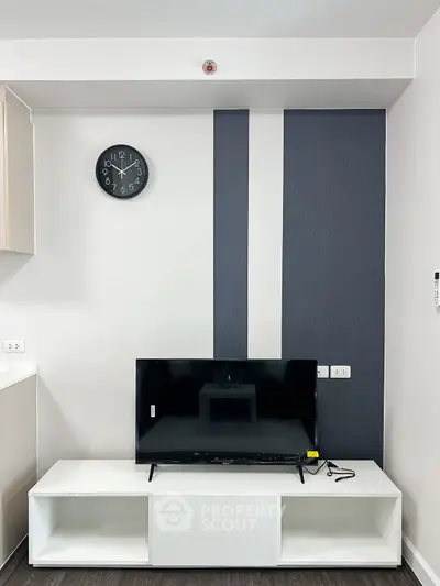 Modern living room with stylish TV setup and wall clock