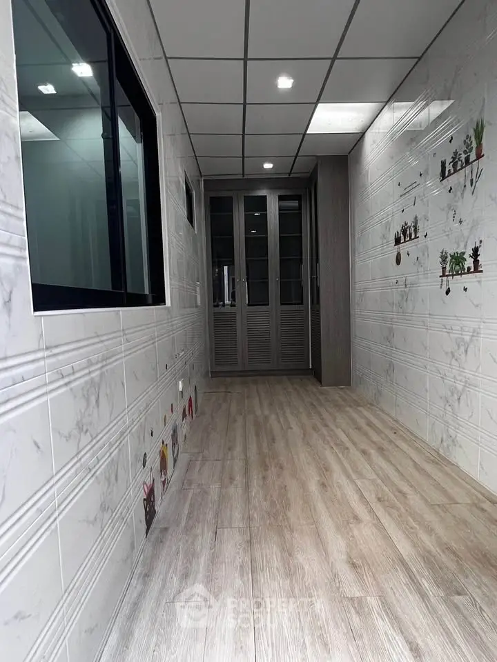 Stylish corridor with modern decor and wooden flooring in a contemporary building.