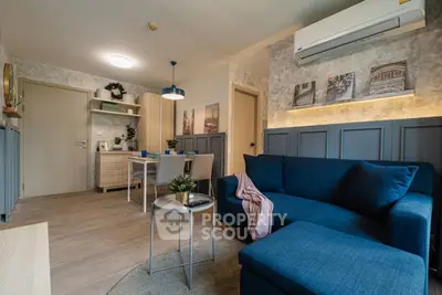 Modern living room with blue sofa, dining area, and air conditioning in stylish apartment.