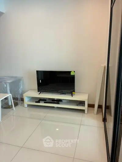 Modern living room with sleek TV stand and glossy tiled flooring, perfect for cozy entertainment.