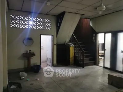 Spacious interior with staircase and vintage charm, ideal for renovation projects.