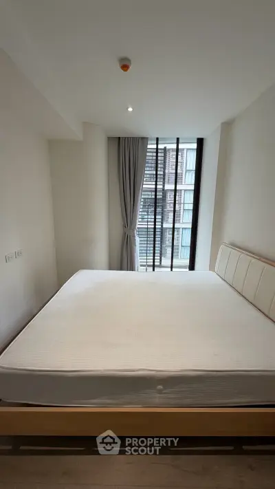Modern bedroom with large window and minimalist design in urban apartment