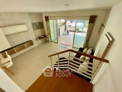 Spacious modern living room with open layout and balcony access, perfect for entertaining and relaxation.