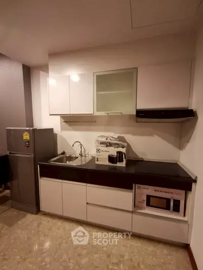 Modern kitchen with sleek cabinetry and built-in microwave oven
