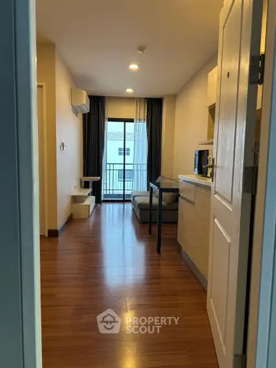 Modern apartment interior with wooden flooring and balcony view