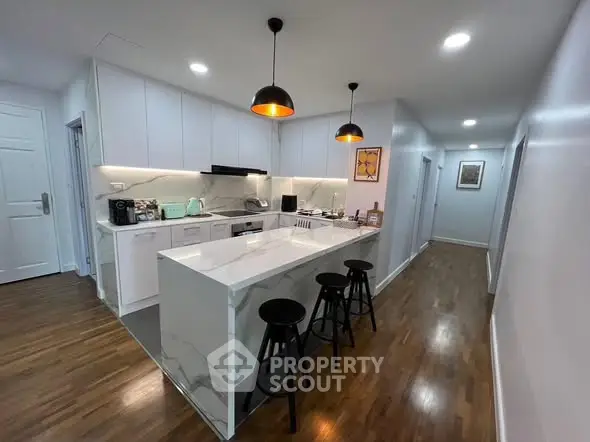 Modern kitchen with sleek white cabinetry and stylish pendant lighting