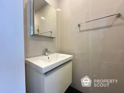 Modern bathroom with sleek sink and mirror in a stylish real estate property.