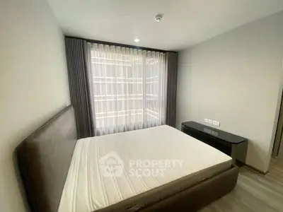 Modern bedroom with large window and stylish furnishings in a contemporary apartment.