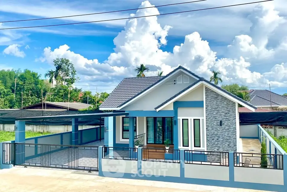 Charming modern house with blue accents and spacious driveway under a bright sky.