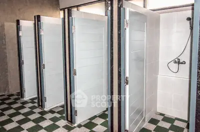 Modern communal shower area with sleek design and privacy doors.