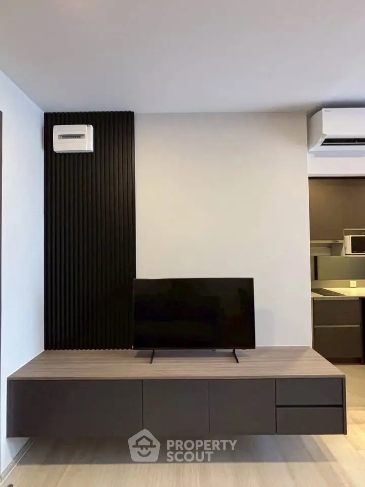 Modern living room with sleek TV stand and air conditioning unit, showcasing contemporary interior design.