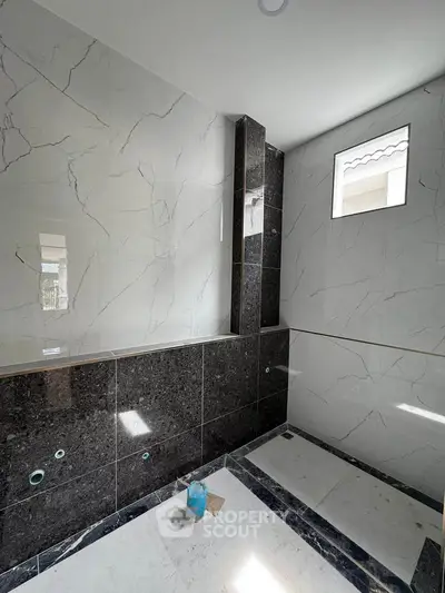 Luxurious bathroom under construction with elegant marble tiles and modern design.