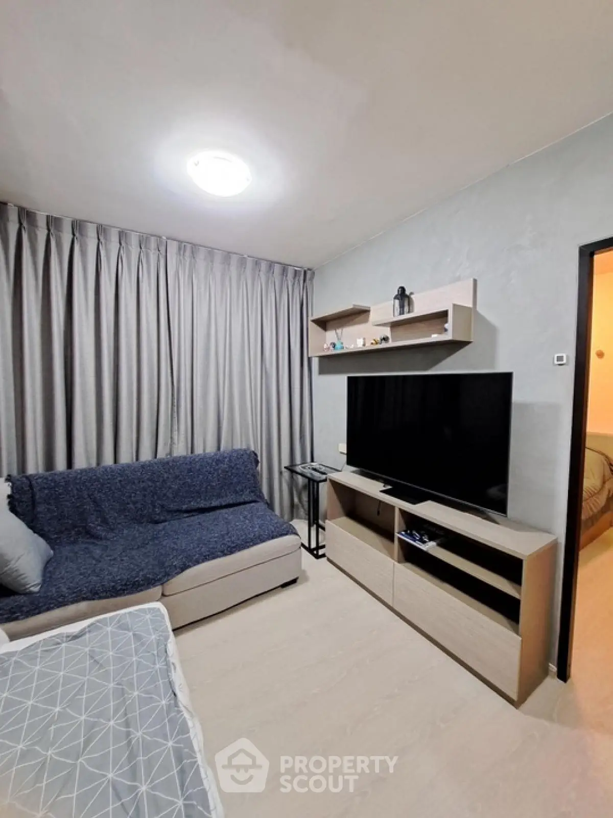 Modern living room with cozy sofa and large TV unit, perfect for relaxation.