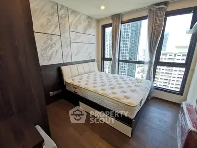 Modern bedroom with large windows and city view in high-rise apartment
