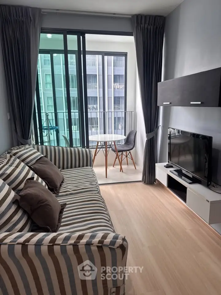 Modern living room with striped sofa and balcony view in stylish apartment