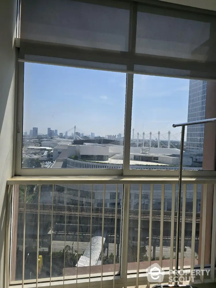 Stunning cityscape view from a modern apartment window with clear blue skies.