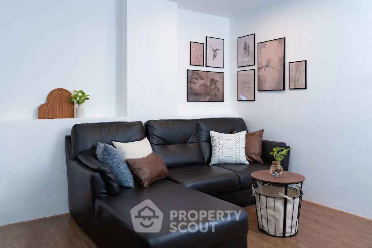 Stylish living room with black leather sofa and modern wall art