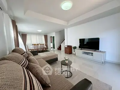 Spacious modern living room with elegant decor and large sofa, perfect for family gatherings.