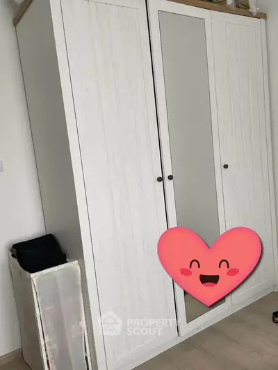 Spacious bedroom with stylish white wardrobe and mirrored door