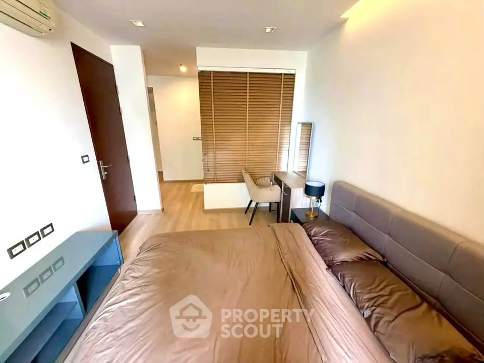 Modern bedroom with stylish decor and natural light, featuring a cozy bed and elegant furnishings.