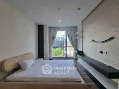 Modern bedroom with large window and minimalist decor in urban apartment