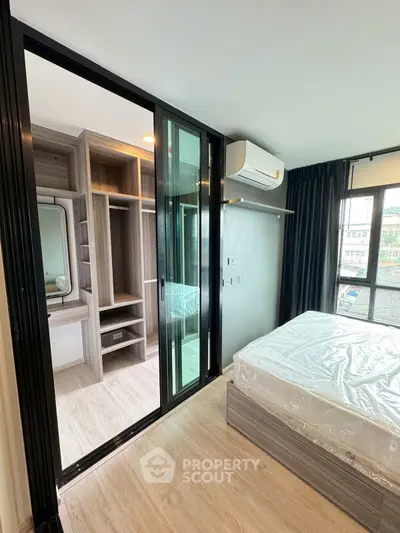 Modern bedroom with sliding glass door and built-in closet, featuring natural light and sleek design.