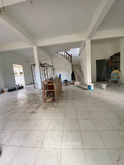 Spacious under-construction interior with open layout and staircase, ideal for customization.