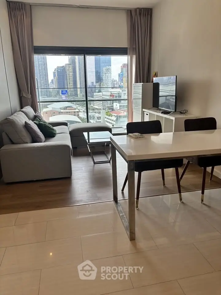 Modern living room with city view, featuring sleek furniture and large windows for natural light.