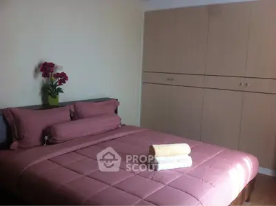 Cozy bedroom with pink bedding and built-in wardrobe, perfect for restful nights.