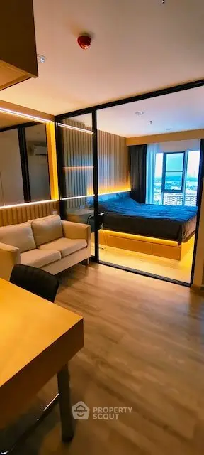 Modern studio apartment with glass partition, cozy living area, and city view.