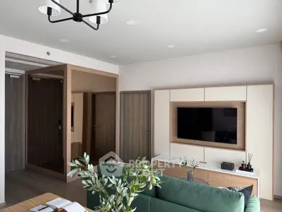 Modern living room with sleek furniture and large TV, perfect for relaxation and entertainment.