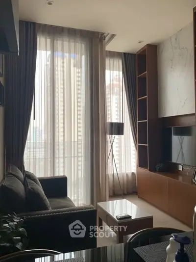 Modern living room with floor-to-ceiling windows and stylish decor in urban apartment.