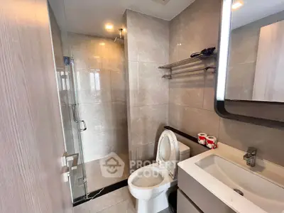 Modern bathroom with sleek design, featuring a glass shower and contemporary fixtures.