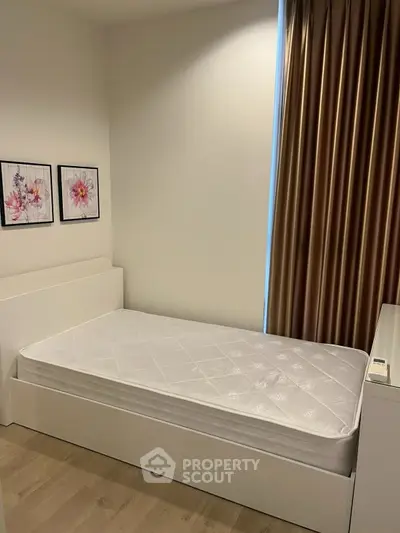 Cozy bedroom with minimalist design featuring a single bed and elegant decor.