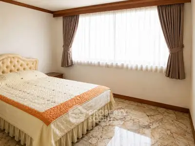 Spacious bedroom with elegant curtains and marble flooring in a luxurious property.