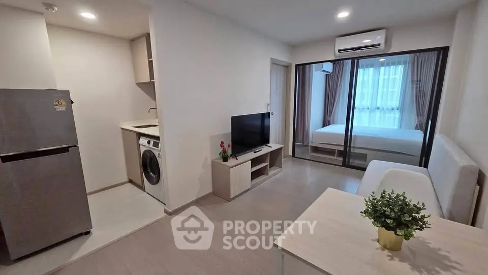 Modern open-plan living room with kitchen and bedroom in a stylish apartment.