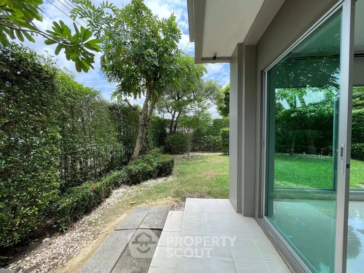 Charming garden view from modern home with lush greenery and glass doors