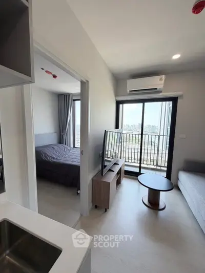 Modern apartment interior with bedroom, living area, and balcony view