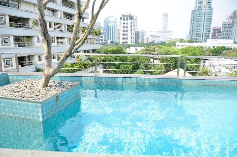 Luxurious rooftop pool with stunning city skyline views in modern urban setting.