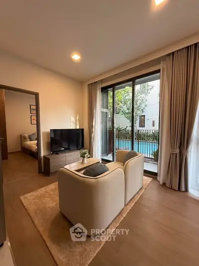 Modern living room with cozy seating and pool view, perfect for relaxation.