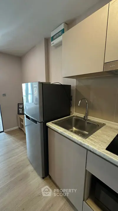 Modern kitchen with sleek appliances and stylish cabinetry in a contemporary apartment.