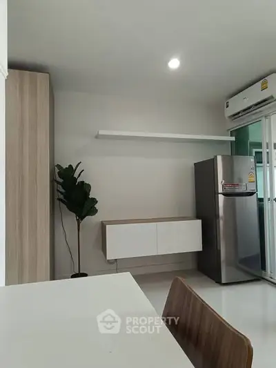 Modern kitchen with sleek cabinetry and stainless steel fridge in a minimalist design.