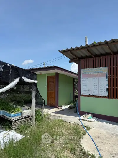 Charming rural property with green exterior and garden area, perfect for sustainable living.