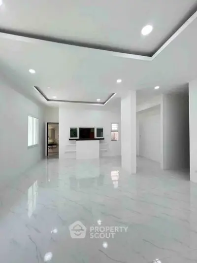 Spacious modern living room with elegant marble flooring and recessed lighting