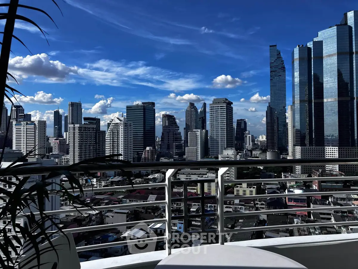 Stunning cityscape view from a modern balcony with sleek railing and vibrant skyline.