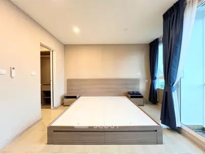 Spacious bedroom with modern design and large windows offering natural light
