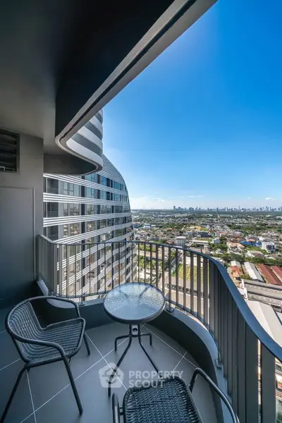 Stunning high-rise balcony with panoramic city views and modern outdoor seating.