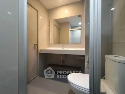 Modern bathroom with sleek fixtures and large mirror in a contemporary home.